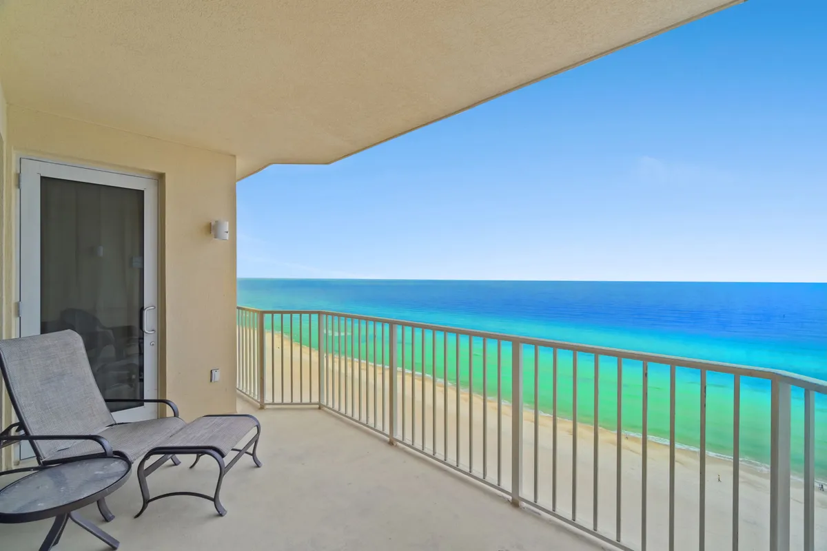 This image features a private balcony high above the beach, with panoramic views of the sea and sand below. The tranquil scene includes comfortable balcony seating, inviting guests to relax and enjoy the fresh ocean breeze and natural beauty.